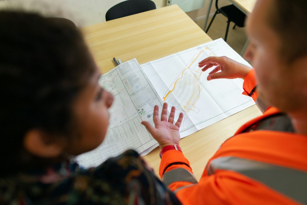Two engineers discussing a project design at a worktable