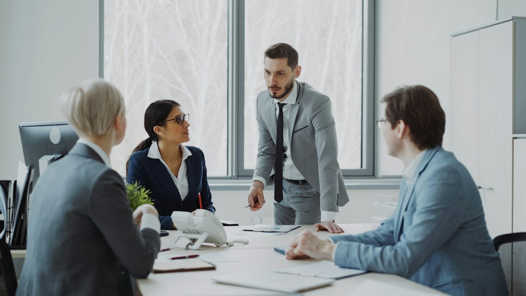 Business professionals reviewing reports around a meeting table in an office